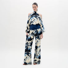 Load image into Gallery viewer, A woman stands against a plain white background wearing a cream and navy blue marble-patterned halter top with matching Como Pants in a wide-leg style.