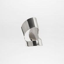 Load image into Gallery viewer, The Artemis Cuff is a smooth, abstract silver metal sculpture with curved and folded surfaces, resembling a silver plated bracelet, showcased against a plain white background.