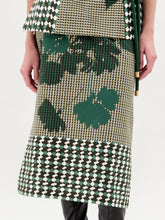 Load image into Gallery viewer, Woman wearing a green skirt with black knee-high boots on a white background
