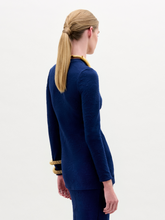 Load image into Gallery viewer, Woman wearing the Celyse Tshirt, a fitted long-sleeve navy top with front knot detail and a flattering silhouette, styled with gold jewelry against a plain white background.