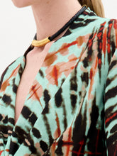 Load image into Gallery viewer, The Hadria Necklace is shown on a plain white background, featuring a black braided leather design with a gold clasp and gold embellishments.