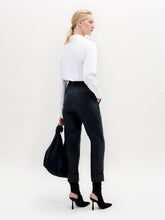 Load image into Gallery viewer, Woman wearing a white blouse and black pants holding a black bag against a white background