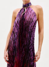 Load image into Gallery viewer, A person wearing the Lucia Dress—a sleeveless, pleated dress with a purple and black abstract pattern—and a matching choker with a gold metallic accent, set against a plain light-colored background.