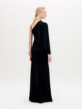 Load image into Gallery viewer, Against a plain background, a person showcases the Shiri Dress, a long black asymmetrical column silhouette crafted from Italian fabric, paired with gold accessories.