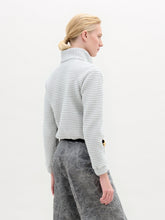 Load image into Gallery viewer, A person stands against a plain white background, wearing the oversized Zalta Jacket made from Italian fabric in a checkered pattern, paired with crinkled gray trousers and hands in pockets.