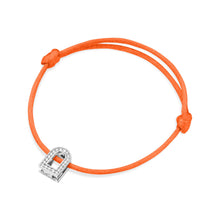 Load image into Gallery viewer, Introducing the L'Arc Voyage Charm PM: an orange silk cord bracelet highlighted by a stunning lock-shaped charm in 18k white gold, embellished with Galerie diamonds. The bracelet is elegantly tied with a simple knot on each side of the charm, evoking the essence of Paris Atelier craftsmanship.