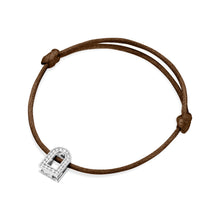 Load image into Gallery viewer, This understated brown silk cord bracelet, named the L'Arc Voyage Charm PM, is crafted from 18k white gold and displays a padlock charm embellished with Galerie diamonds, reflecting the elegance typical of a Paris Atelier design. The timeless padlock form brings sophistication to its minimalist allure, accentuated by touches of diamonds.