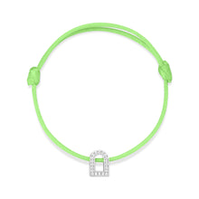 Load image into Gallery viewer, The L'Arc Voyage Charm PM bracelet from Paris Atelier features a neon green silk cord with an adjustable knot design and a silver charm shaped like a curved arch. This elegant piece, crafted in 18k white gold and embedded with Galerie diamonds, is beautifully displayed against a plain white background.