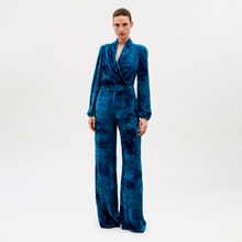 Load image into Gallery viewer, Woman wearing a blue velvet jumpsuit on a white background

