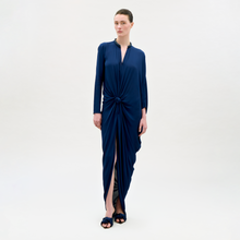 Load image into Gallery viewer, Woman wearing a blue dress with a knot detail on a white background
