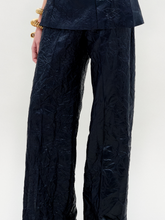 Load image into Gallery viewer, A person wearing the Emine Pant in color navy with a golden bracelet on a white background.
