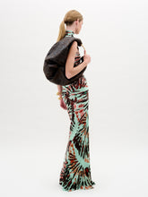 Load image into Gallery viewer, A woman wears the Frances Dress, a sleeveless, slim-fit maxi with a high neckline, holding a dark jacket over her shoulder against a plain white background.
