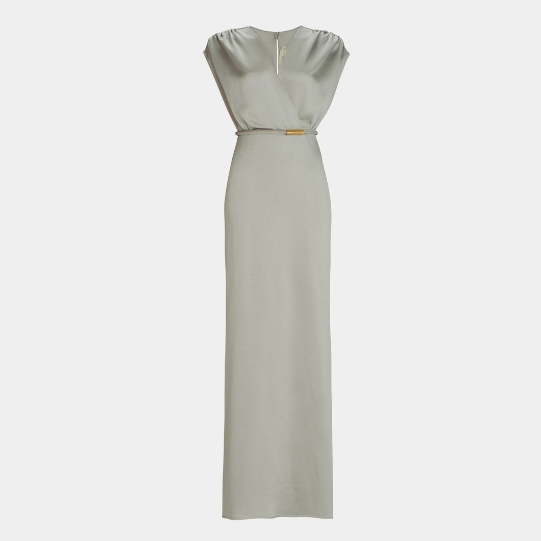 The Freda Dress is a sleeveless, floor-length light gray maxi dress with a V-neckline, gathered shoulders, and a slim waist belt, crafted from luxurious Italian fabric for a refined, fitted silhouette.