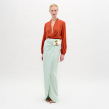Load image into Gallery viewer, Woman wearing an orange blouse and light green skirt on a white background
