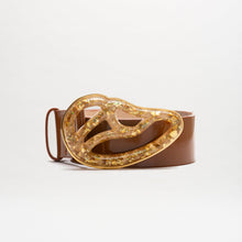 Load image into Gallery viewer, The Nala Belt is a wide brown Italian leather belt with a large, abstract Petralux buckle accented by embedded gold flakes. Made in Colombia, it’s displayed against a plain white background.
