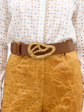 Load image into Gallery viewer, The Nala Belt is a wide brown Italian leather belt with a large, abstract Petralux buckle accented by embedded gold flakes. Made in Colombia, it’s displayed against a plain white background.

