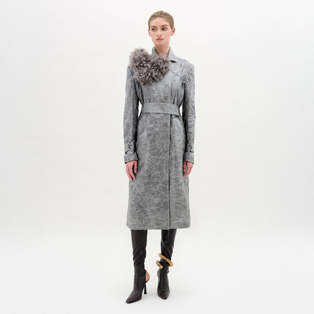 Woman wearing a gray coat with a decorative element on a white background