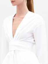 Load image into Gallery viewer, Person wearing the Saanvi Blouse White with lace detail and coordinating white pants, holding a small handbag, looking off to the side against a plain background. Don't miss your chance to pre-order this stunning outfit by the ship-by date of February 15th, 2025.
