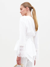 Load image into Gallery viewer, Person wearing the Saanvi Blouse White with lace detail and coordinating white pants, holding a small handbag, looking off to the side against a plain background. Don't miss your chance to pre-order this stunning outfit by the ship-by date of February 15th, 2025.
