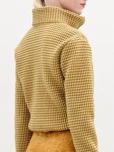 Load image into Gallery viewer, A woman wears the Zalta jacket, a brown sweater with an oversized fit, paired with gold pants.
