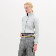 Load image into Gallery viewer, A person stands against a plain white background, wearing the oversized Zalta Jacket made from Italian fabric in a checkered pattern, paired with crinkled gray trousers and hands in pockets.
