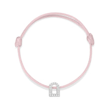 Load image into Gallery viewer, The L'Arc Voyage Charm PM bracelet from the Paris Atelier collection elegantly showcases an 18k white gold, arch-shaped charm embellished with Galerie diamonds. It is beautifully set on a delicate pink silk cord, featuring an adjustable design for a secure fit.
