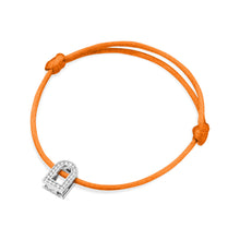 Load image into Gallery viewer, The L'Arc Voyage Charm PM bracelet, crafted in the Paris Atelier, features an exquisite 18k white gold charm adorned with Galerie diamonds on an adjustable orange silk cord.
