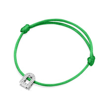 Load image into Gallery viewer, Introducing the L'Arc Voyage Charm PM bracelet from Paris Atelier, featuring a luxe silk cord in green adorned with an 18k white gold lock-shaped charm enhanced by elegant Galerie diamonds. The design includes two adjustable knots on either side of the charm, adding sophisticated elegance to this exquisite piece.

