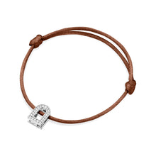 Load image into Gallery viewer, The L'Arc Voyage Charm PM bracelet from the Paris Atelier showcases a small charm crafted in 18k white gold, adorned with Galerie Diamonds, and is set on a silk cord. The adjustable knots on either side of the charm make it easy to fit.
