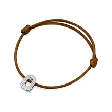 Load image into Gallery viewer, The L'Arc Voyage Charm PM bracelet by Paris Atelier features an 18k white gold lock-shaped charm adorned with Galerie Diamonds, set on a brown silk cord with adjustable knots.
