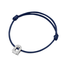 Load image into Gallery viewer, Introducing the L'Arc Voyage Charm PM, a silk cord bracelet in dark blue with an 18k white gold charm adorned with Galerie diamonds. Crafted in the Paris Atelier, this elegant piece features adjustable knots on each side of the charm for a secure fit.
