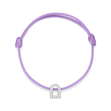 Load image into Gallery viewer, The L'Arc Voyage Charm PM bracelet is a purple braided silk cord accessory that features an 18k white gold charm adorned with Galerie diamonds, shaped like an archway. Lovingly crafted by Paris Atelier, the centrally placed charm nestles perfectly between adjustable knots for a customized fit, its elegant design standing out against a plain white background.
