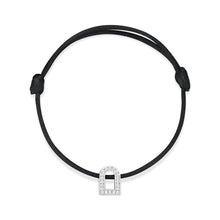 Load image into Gallery viewer, The L'Arc Voyage Charm PM bracelet, crafted by the Paris Atelier, showcases a minimalistic and elegant design. This piece features an 18k white gold charm shaped like a padlock, embellished with Galerie diamonds and set on an adjustable silk cord, adding sophistication to any look.
